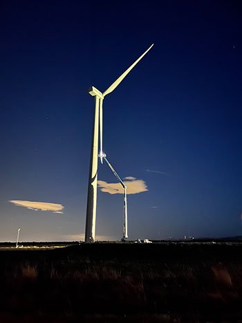 A technician on an extended aerial lift installs instrumentation on the wind turbine blade. Transitioning the wind turbine from upwind to downwind took weeks. Image by Pietro Bortolotti, NREL